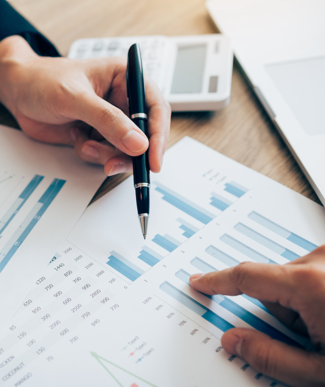 The accounting staff of the company are jointly analyzing the graph of the expenses on the desk in the office.